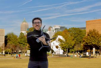 Tarek Rakha on the Georgia Tech campus holding a drone in his arms.