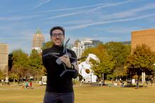 Tarek Rakha on the Georgia Tech campus holding a drone in his arms.