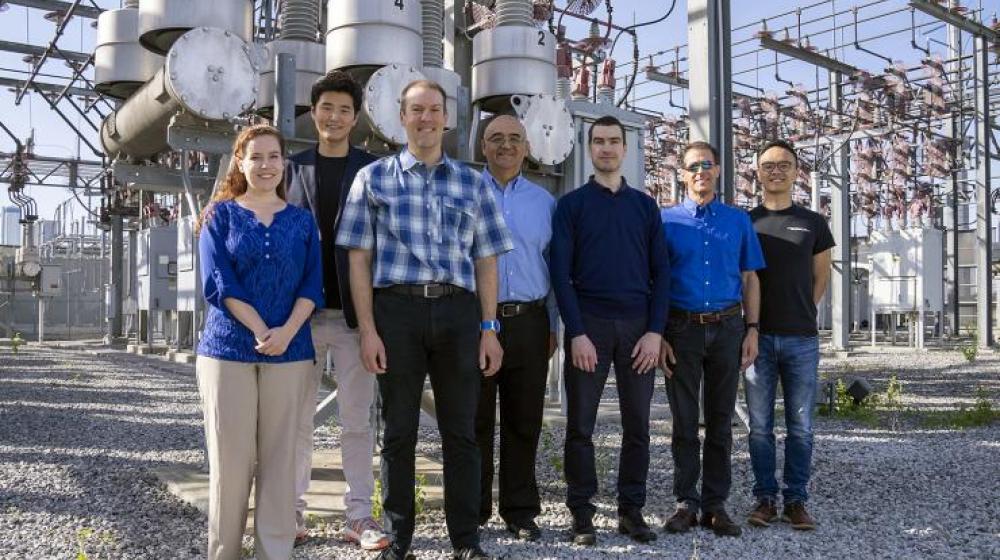 The TESLA (Tough and Ecological Supercritical Line Breaker for AC) team in front of high-voltage circuit breakers. 