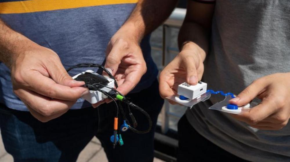 Close-up view of Omer Inan and Samer Mabrouk holding prototypes of their new sensor